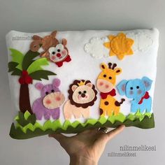 someone is holding up a pillow with animals on it