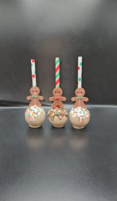 three gingerbread man ornaments with candy canes on them