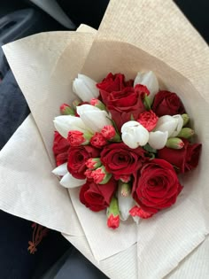 a bouquet of red roses and white tulips