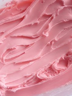 a close up view of pink frosting in a container