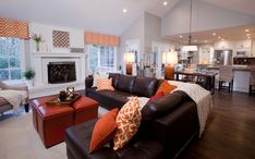 a living room filled with furniture and a fire place in the middle of a kitchen