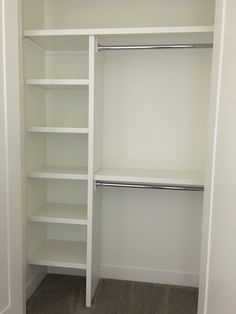 an empty walk in closet with white shelving and carpeted flooring on the ground