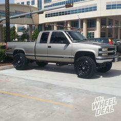 a silver truck parked in front of a building