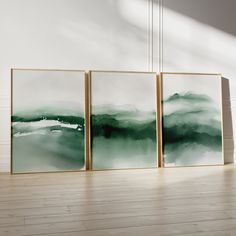 three paintings hanging on the wall in an empty room with wood flooring and white walls