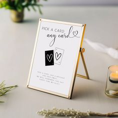 a sign that says pick a card and any card is on the table next to some flowers