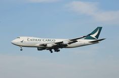 a cathay cargo plane flying in the sky with it's landing gear down