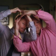 two men standing next to each other holding their hands up