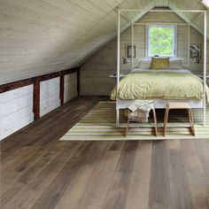 an attic bedroom with hardwood floors and white walls