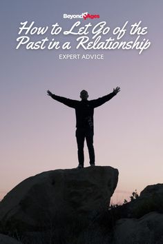 a man standing on top of a rock with his arms outstretched