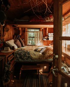 a bed sitting in the middle of a bedroom next to a wooden desk and window