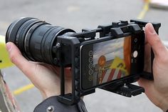 a person holding up a camera to take a photo on the street with their cell phone