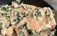 salmon with spinach and mushrooms in a skillet