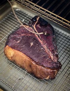 a large piece of meat sitting on top of a grill grates in an oven