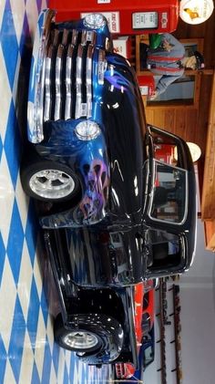 the front end of a black and white car with skulls on it's hood