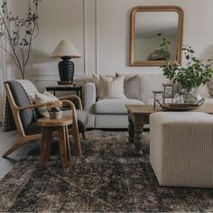 a living room filled with furniture and a large mirror on the wall above it's headboard