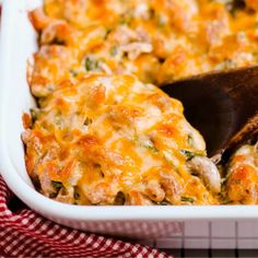 a casserole dish with chicken and cheese in it on a red and white checkered cloth