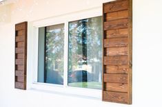 a window with wooden shutters and white walls