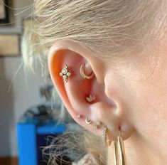 a close up of a person's ear with three different piercings on it