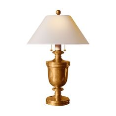 a gold lamp with a white shade on it