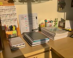 a wooden desk topped with lots of books and notebooks