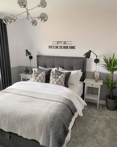 a bedroom with a bed, nightstands and plants