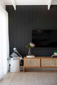 a flat screen tv mounted to the side of a wooden cabinet in a living room