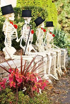 three skeleton statues sitting on top of a planter