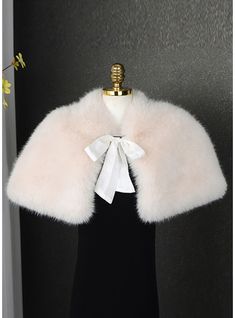 a white fur collar on a mannequin with a black dress and flowers in the background