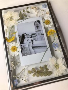 a photo frame with flowers and leaves around it