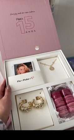 a person holding a pink box with jewelry in it