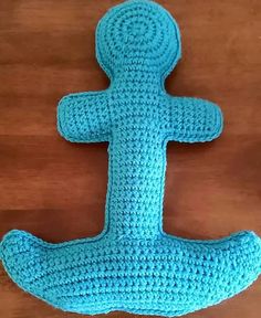 a crocheted blue object sitting on top of a wooden table