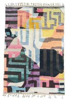 a multicolored rug with fringes on the bottom and an abstract design in the middle