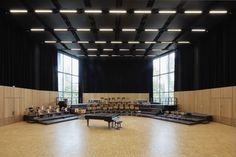 an empty concert hall with a piano in the middle