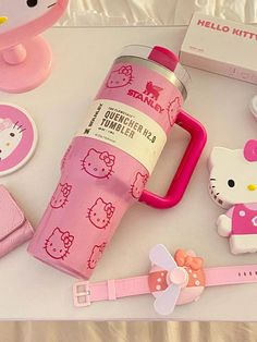 a hello kitty water bottle and other items are on a table with white cloths