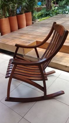 a wooden rocking chair sitting on top of a tiled floor