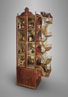 a tall wooden display case filled with lots of things on top of it's sides