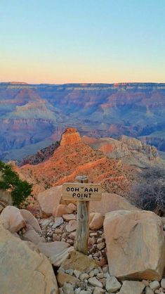 a wooden sign sitting on the side of a cliff