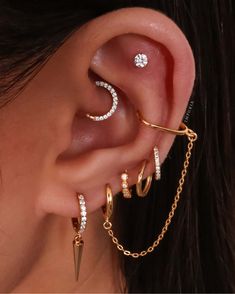 a woman wearing three different ear piercings