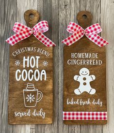 two wooden christmas tags with gingerbread and hot cocoa on them, hanging from a wood wall