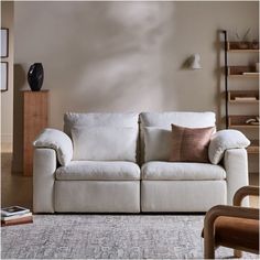 a white couch sitting in a living room on top of a rug