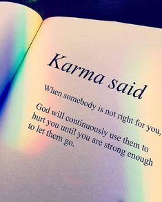 an open book with the words karma said on it's page and rainbow light