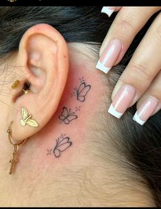 a close up of a person's ear with butterflies on it