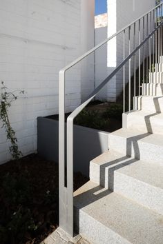 the stairs are made of concrete and have metal handrails that lead up to it