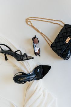 Flat lay view of the Bermuda Black Patent Open Toe Heel which features black patent leather, multiple straps, open- pointed toe and stretchy back strap closure Faux Leather Purse, Studded Necklace, Travel Dress, Faux Leather Belts, Jumpsuit Shorts Rompers, Bar Earrings, Toe Designs, Leather Belts, Black Patent Leather