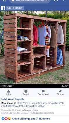 an outdoor storage unit made out of wooden pallets with clothes hanging on the racks