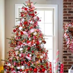 a decorated christmas tree in front of a window