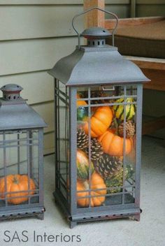 a lantern filled with pumpkins and pine cones