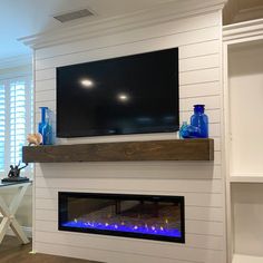 a flat screen tv mounted above a fireplace in a living room