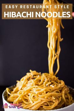 someone is eating noodles with chopsticks in a white bowl on a black table