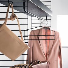 a woman's purse and jacket hanging on a rack